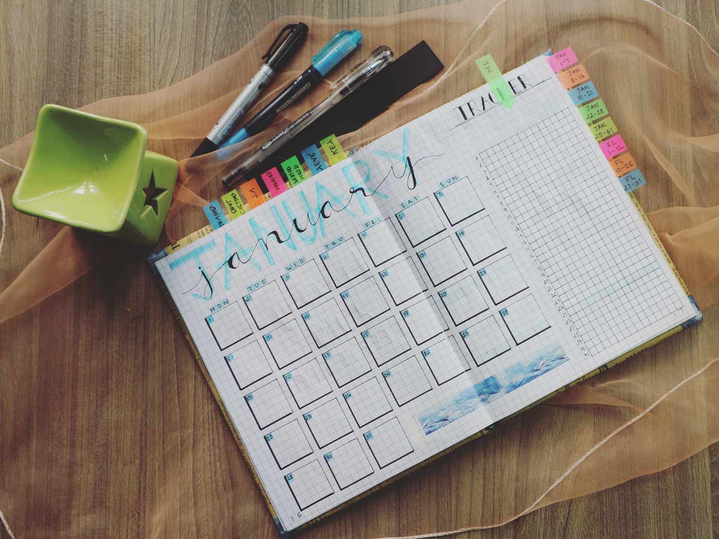 Aufgeschlagener Kalender, zusammen mit Stiften und Notizzetteln