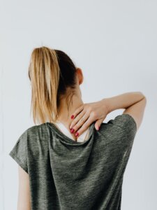 Schmerzen lindern Faszien Frau hält sich den schmerzenden Nacken