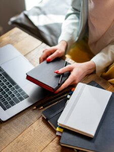 Viele Notizbücher und ein Notebook auf einem Schreibtisch