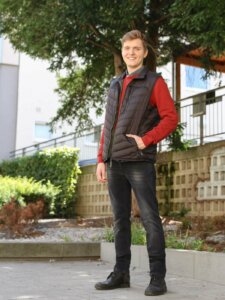 Warme Kleidung Herren Weste Junger Mann trägt Jeans, Pullover und Weste