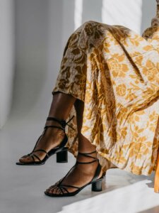 Schuhtrend 2022 Schnürungen Detailbild geschnürter Sandalen mit einem floralen Rock