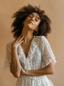 Damenmode Punkte Print Frau trägt weißes Kleid mit Punkten