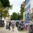Menschen gehen durch die Hildesheimer Fußgängerzone, an den Seiten Bekleidungsstände