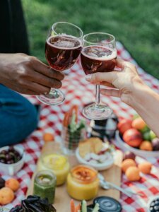 Zwei Menschen stoßen auf einer Picknickdecke an 