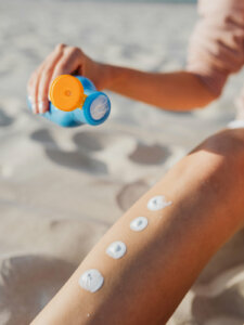 Sonnencreme UV-Schutz Sonnencreme auf einem Bein