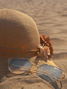 Sonnenschutz verwenden Sonnenhut und Sonnenbrille im Sand