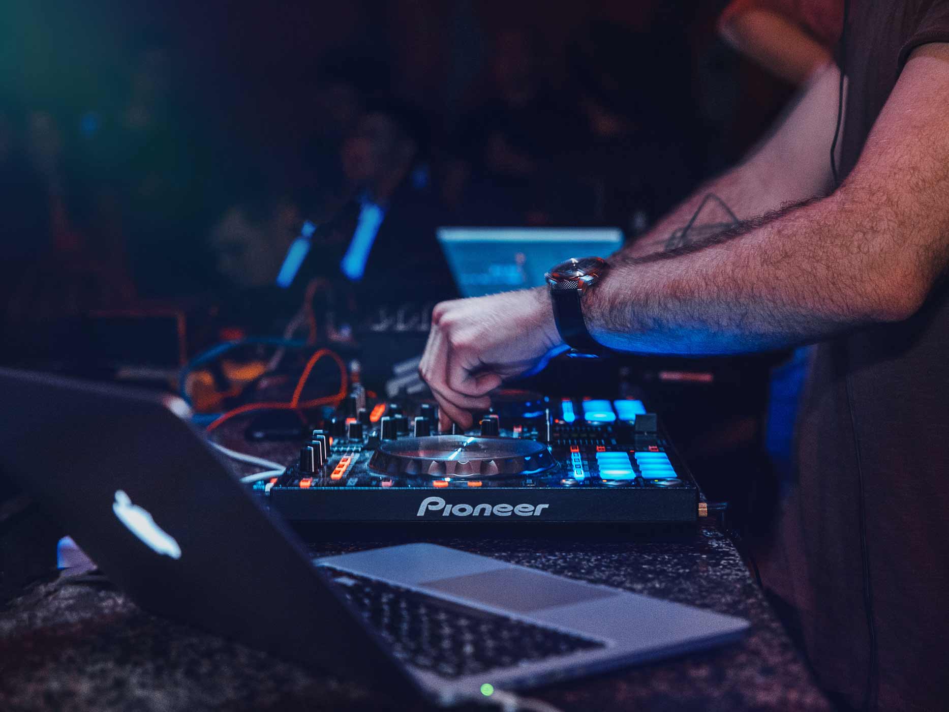 DJ-Pult mit Laptop und Händen vom DJ