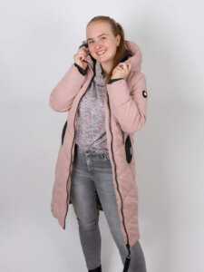 Damen Übergangsjacke stylen Junge Frau trägt rosafarbene Jacke mit Pullover und grauer Jeans
