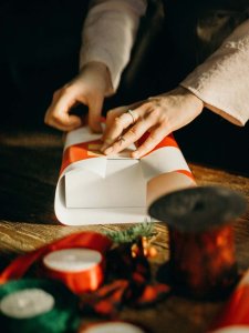 Weihnachtswünsche erfüllen Jemand packt ein Geschenk ein