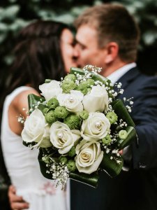 Hochzeit feiern Hildesheim Brautpaar küsst sich hinter dem Brautstrauß