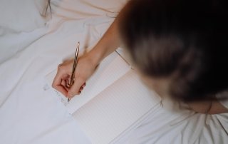 Ansicht von oben, wie eine Frau eine To-Do-Liste schreibt
