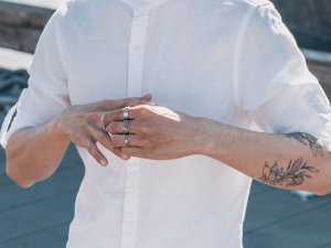 Herrenschmuck Ringe Gesichtsloser Mann trägt weißes Hemd und umfasst Ring am Finger
