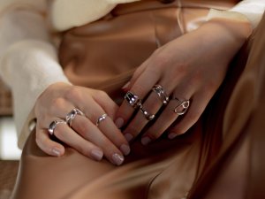 Hände einer Frau mit vielen verschiedenen Ringen