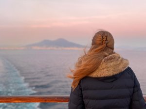 Junge Frau mit Klammer im Haar blickt aufs Meer