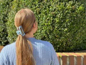 Tiefsitzender Zopf Frisur Junge Frau mit Haarklammer im blonden Haar