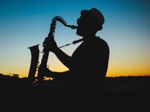 Silhouette eines Mannes mit einem Saxophon spielend bei Sonnenuntergang
