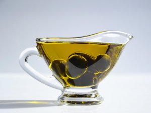 Gefäß mit Olivenöl und Oliven