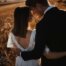 Ein Brautpaar steht im Sonnenuntergang vor einem Getreidefeld und lehnt verliebt die Köpfe aneinander
