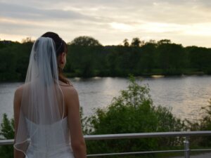 Braut steht auf der Terrasse vom Ahoi am Hohnsensee
