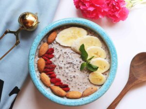 Eine Schüssel mit Porridge, getoppt mit Mandeln, Bananen und Beeren