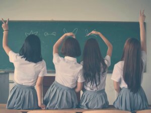 Vier Schulmädchen sitzen vor einer Schultafel