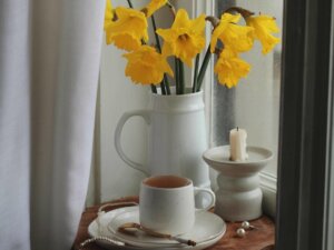 Narzissen stehen in einer Vase auf einem kleinen Kaffeetischchen