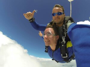 Tandemfallschirmspringer über den Wolken