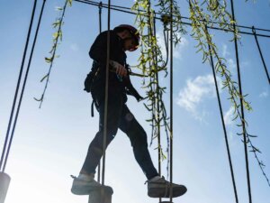 Kletterer geht über ein Hindernis im Hochseilgarten