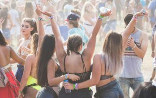 Mehrere Mädchen umarmen sich und feiern auf einem Festival