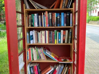 Roter Bücherschrank mit vielen Büchern