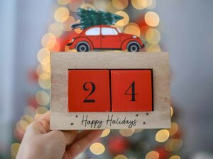 Jemand hält einen Holzkalender mit zwei Holzblöcken, die eine 24 bilden in der Hand.