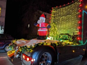 Ein aufblasbarer Weihnachtsmann ist auf der Rückseite eines dekorierten LKWs zu sehen.