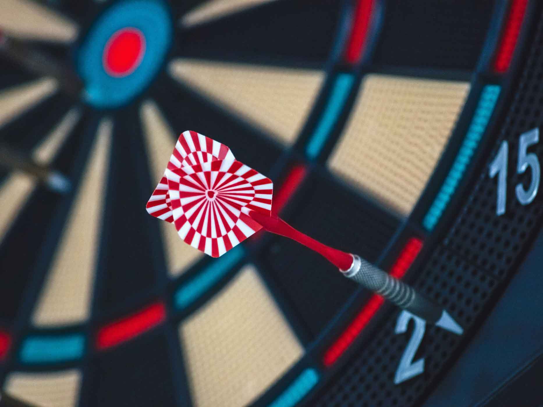 Darts Scheibe Ein Darts Pfeil steckt neben der Darts Scheibe